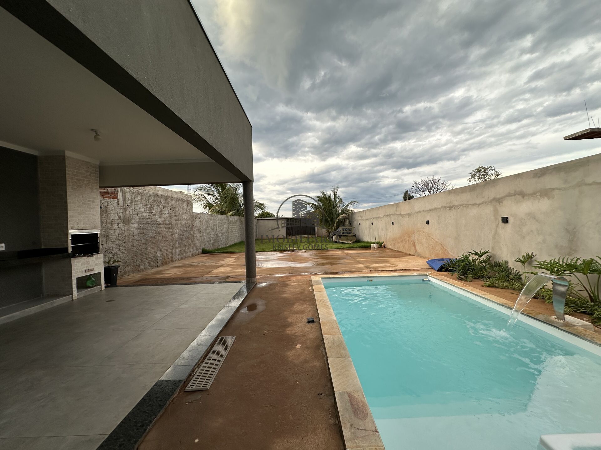 Área gourmet coberta com churrasqueira ao lado da piscina