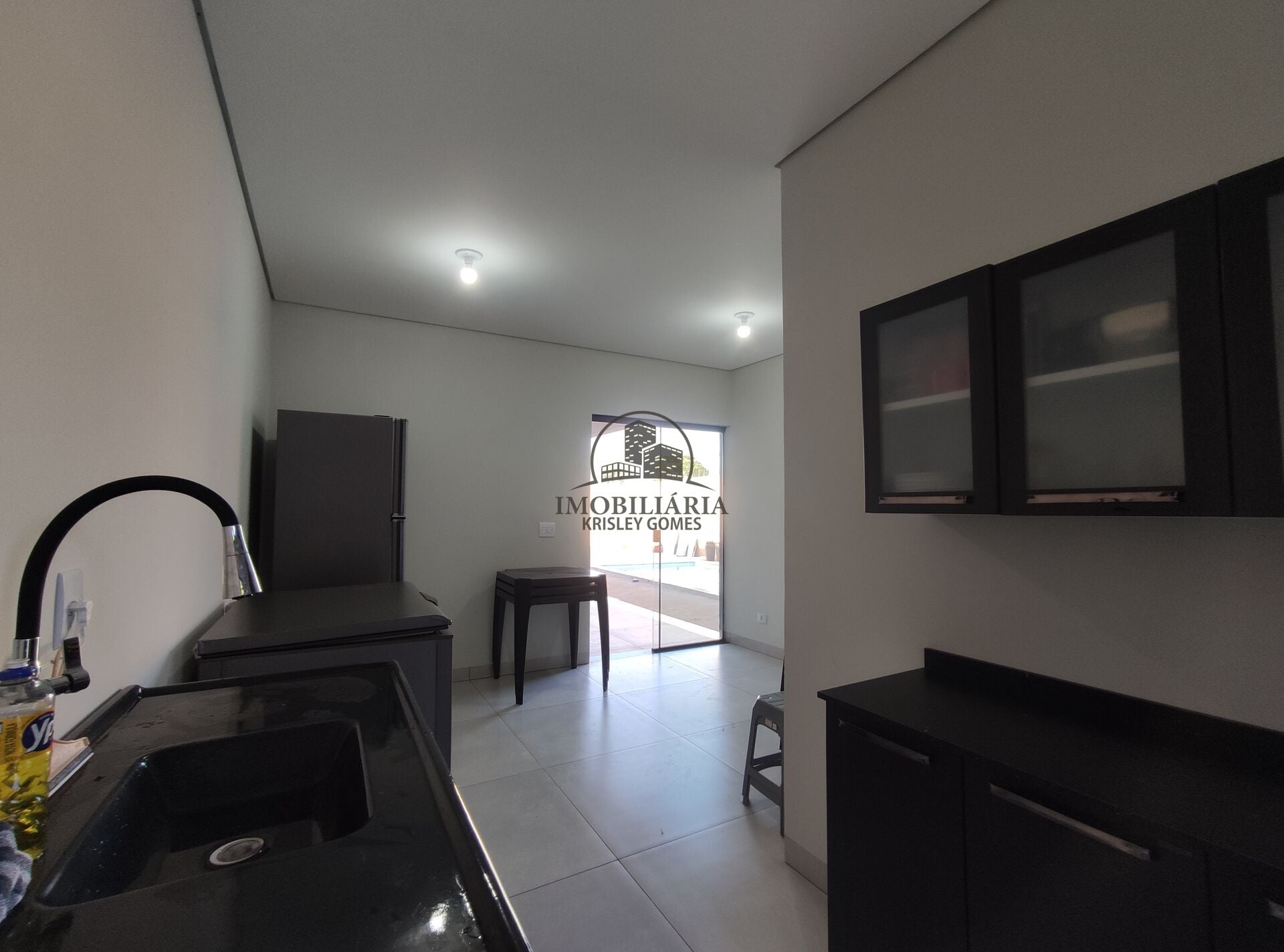 Cozinha com armários pretos, pia e bancada