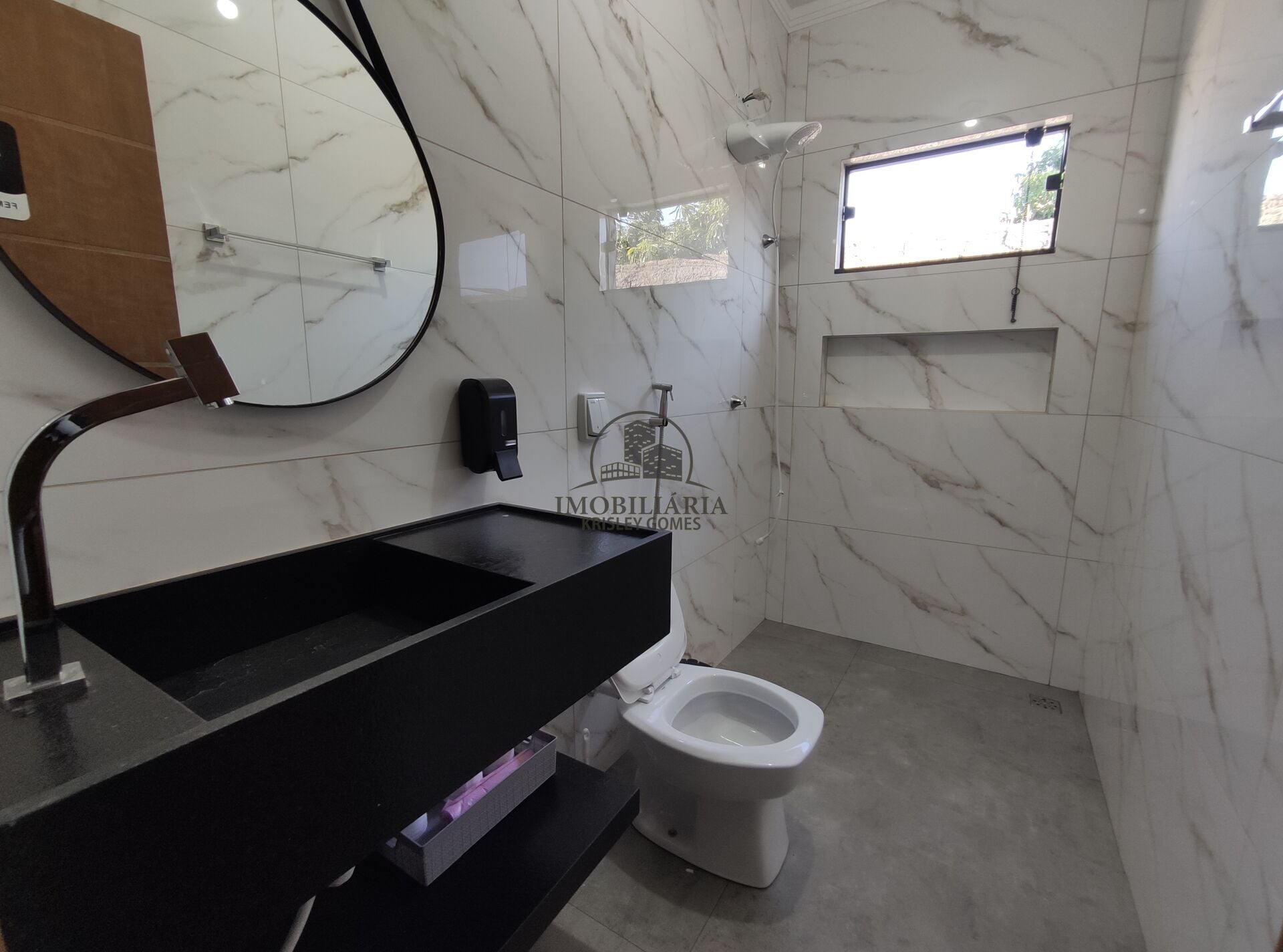 Banheiro em porcelanato marmorizado com bancada preta